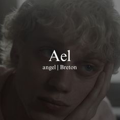 a young man with curly hair is looking at the camera and has his hand on his face