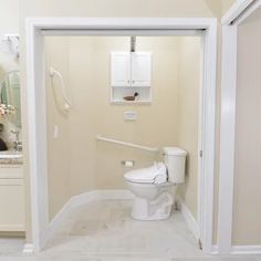 a white toilet sitting inside of a bathroom next to a sink