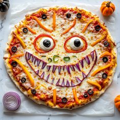 a pizza with an evil face made out of cheese and toppings on the top