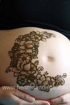 a pregnant belly with henna tattoos on it