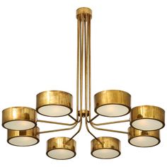 a large brass chandelier with six lights and five circular shades on the bottom