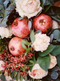 an arrangement of flowers and apples are arranged on the table for this photo opulent