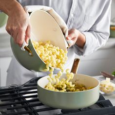 a person pouring corn into a pot on top of a stove with other food items