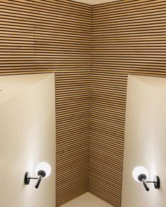 two urinals are shown in the corner of a room with wood slats on the walls