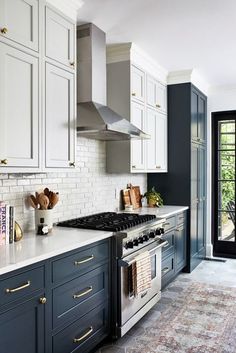 a kitchen with white and blue cabinets, an oven, stove and door leading to a patio