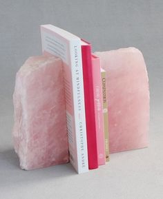 two bookends made out of pink and white books sitting next to each other