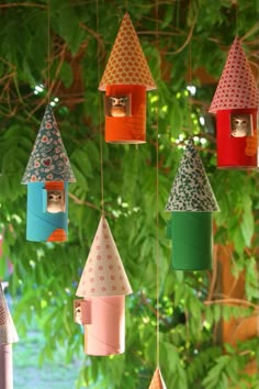 a group of colorful birdhouses hanging from a tree