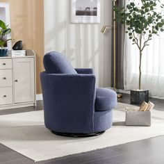 a blue chair sitting on top of a white rug in a living room next to a potted plant