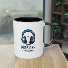 a white and black coffee mug with the words piss off i'm gaming on it