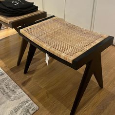 two wooden benches sitting on top of a hard wood floor next to a white rug