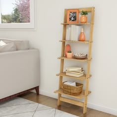 a living room with a white couch and a wooden ladder shelf filled with books on it