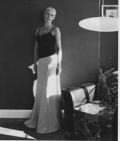 an old photo of a woman standing in front of a mirror with her hands on her hips