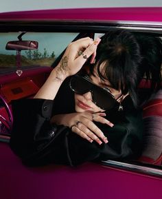 a woman sitting in the drivers seat of a car with her hands on her face