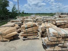 many large rocks are stacked on pallets in the middle of an open area with barbed wire around them