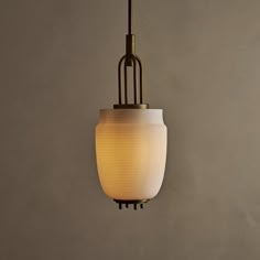 a light hanging from a ceiling fixture in a room with concrete walls and flooring