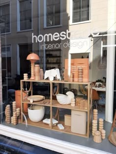 a window display with pottery and other items in the store's windowsills