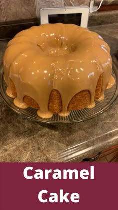 a cake sitting on top of a glass plate covered in caramel icing next to a microwave