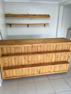 a large wooden dresser sitting on top of a tiled floor next to a white wall