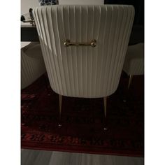 a white chair sitting on top of a red rug