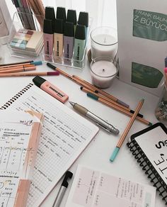 the desk is cluttered with pens, notebooks and other items that are on it