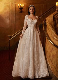 a woman in a wedding dress standing on the stairs with her hands on her hips