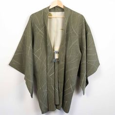 An elegant willow green rinzu (damask) silk with a combination of a woven and off-white printed abstract pampas grass pattern.  Susuki or pampas grass is one of the seven 'flowers of autumn' or aki-no-nanakusa and is usually represented by gentle arcs reminiscent of grass fronds. The haori is lined with an cream silk decorated with a sparse print of kutani ware pottery and fastened with hand-braided pale grey ombre silk ties. Rinzu is a silk damask fabric in which a subtle, repeat satin pattern Satin Pattern, Grass Pattern, Willow Green, Damask Fabric, Grey Ombre, Cream Silk, Kimono Jacket, Pampas Grass, Silk Ties