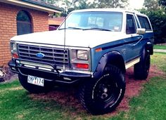 a white and blue truck parked in front of a house