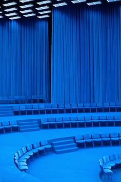 an empty auditorium with blue curtains and seats