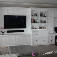 a living room filled with furniture and a flat screen tv mounted on a wall above a fireplace