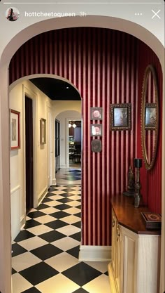 the hallway is decorated with red and white striped wallpaper, black and white checkered floor