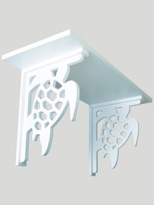 a white shelf with an intricate design on it's top and the bottom section