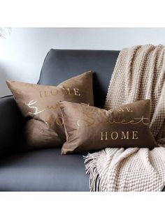 two brown pillows sitting on top of a black couch