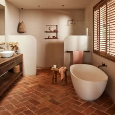 a bathroom with brick flooring and a large bathtub next to a sink in the corner