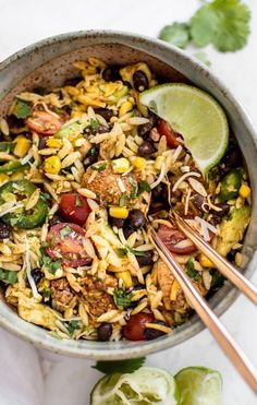 a bowl filled with mexican rice salad and chopsticks