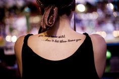 the back of a woman's neck with words written in cursive writing