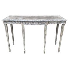 an antique console table with two legs and a marble top, in silver leaf pattern