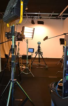 a camera and some lights in a room with other equipment on the floor next to it