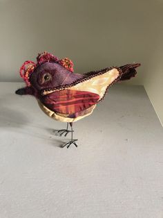 a close up of a small bird on a white surface with a light in the background