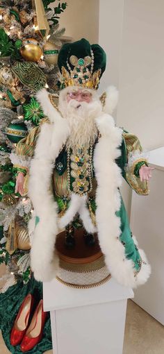 a statue of santa claus in front of a christmas tree