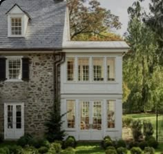 a stone house with white trim and windows