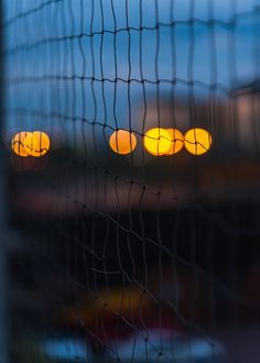 the view from behind a net at sunset, with blurry lights in the background