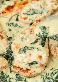 spinach and cheese sauce being stirred in a skillet with a spatula on top