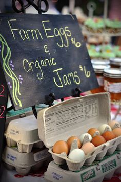 an egg carton with eggs in it next to a sign that says farm eggs and organic tons