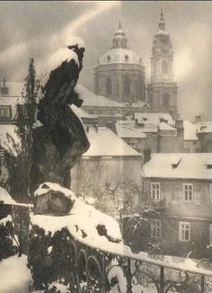 the statue is covered in snow and surrounded by buildings