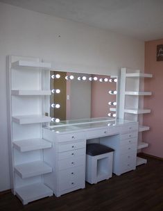 a white dressing table with lights on it