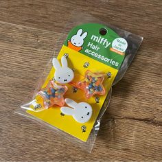 two little bunny hair accessories sitting on top of a wooden table