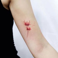 a woman's arm with a red flower tattoo on it