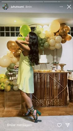 a woman in a yellow dress is holding balloons