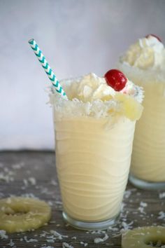 two glasses filled with ice cream and topped with a cherries garnish on top