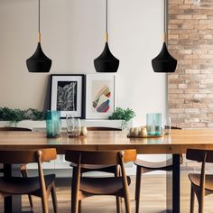 a dining room table with chairs and hanging lights